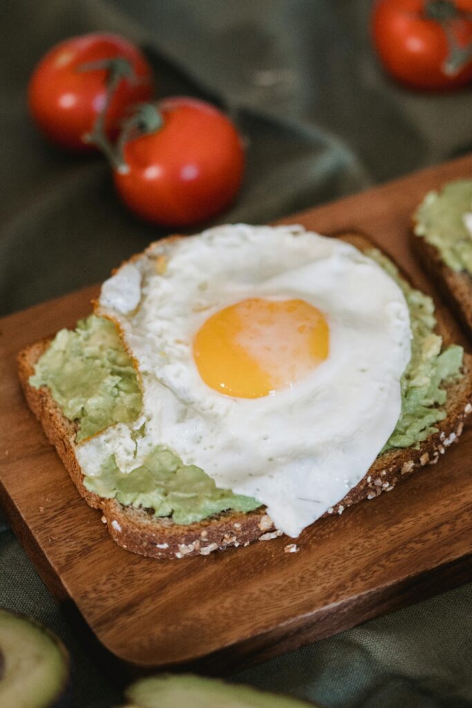 pexels-photo-7936959-7936959 Close-up of avocado toast topped with a fried egg, perfect brunch meal.